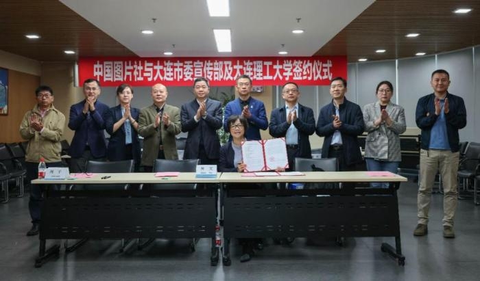 中国图片社党委常委、副总裁黄文(北京)在展示同大连市委宣传部分管日常工作的副部长张金双(大连)签署的战略合作协议。